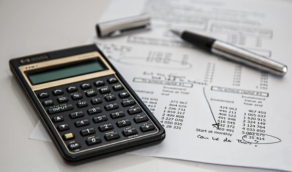 Hay una calculadora y un lapicero donde se ve como se esta haciendo cuentas para definir el presupuesto y poder comprar una licuadora buena 